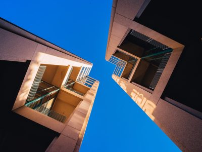 A frog's eye view of architectural twin buildings against a clear blue sky